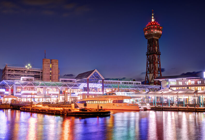 ベイサイドプレイス博多と博多ポートタワーの夜景。ライトアップされた建物と水面に映る光が美しい港の風景。