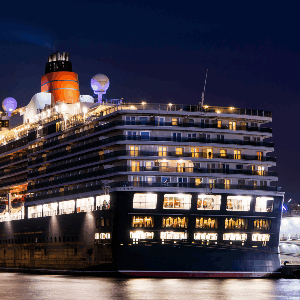 夜の博多港に停泊する大型クルーズ船。ライトアップされた船体が水面に美しく映る様子。